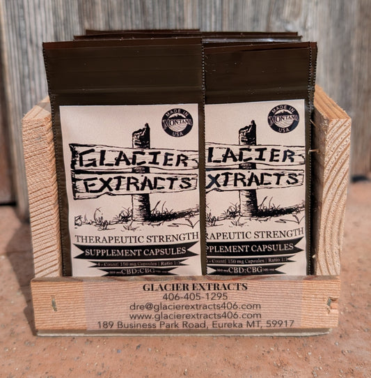Glacier Extracts CBD:CBG Ratio capsule pouches in a branded wooden countertop display